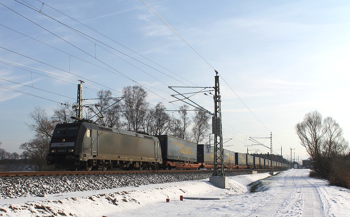 Die MRCE 185 564-2 mit einem Taschenwagenzug bei tiefstehender Wintersonne am 23.01.2014 in Nassenheide.
Die Lok wurde 2005 bei Bombardier in Kassel unter der Fabriknummer 33767 gebaut.