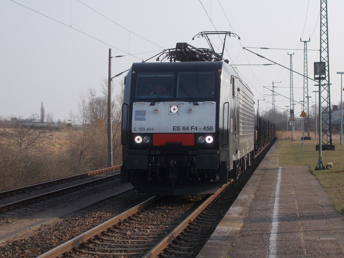 Die MRCE ES64F4 458,mit dem leeren Rohrzug,von Mukran kommend,am 12.April 2018,beim Halt in Altefähr.