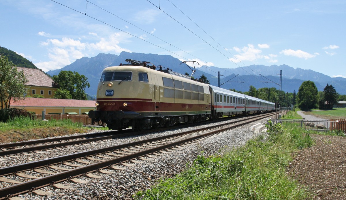 Die Münchener 103 245-7 ist mit dem Sonntags-IC 1284 Schwarzach St.Veit-Flensburg am ehemaligen BÜ in Niederaudorf unterwegs. Dieser wird jetzt durch eine Unterführung ersetzt. Im Hintergrund ist das Kaisergebirge bei Kufstein gut zu sehen.