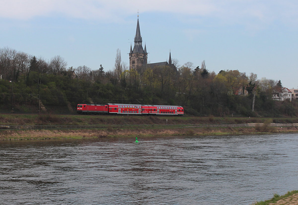 Die RB 18318 (Dresden Hbf - Elsterwerda-Biehla) hat am 09.04.2016 gerade Dresden-Cotta verlassen und wird gleich in Dresden-Kemnitz wieder zum stehen kommen, dabei passiert Sie die Briesnitzer Kirche. Schublok war die 143 283-0.