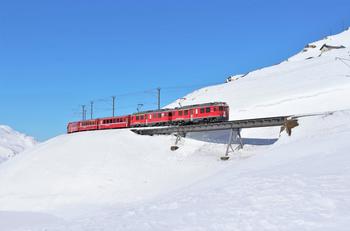 Die RhB ABe 4/4 III Nr. 55  Diavolezza  und 56  Corviglia  durchqueren am 21. Februar 2018 mit dem etwas verspätetem Regio 1625 von St. Moritz - Tirano zwischen Ospizio Bernina und Alp Grüm die 46 Meter lange  Westernbrücke .
