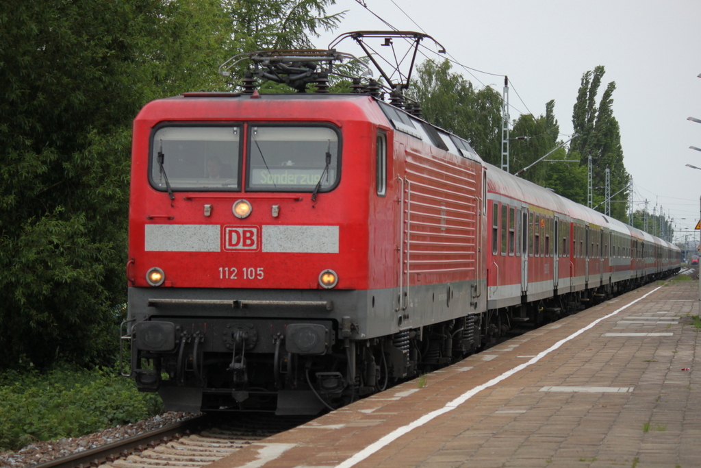 Die Rostocker 112 105-2 mit Sonderzug 13290 von Warnemnde nach Berlin-Zoo bei der Durchfahrt am 28.05.2015 im Haltepunkt Rostock-Holbeinplatz