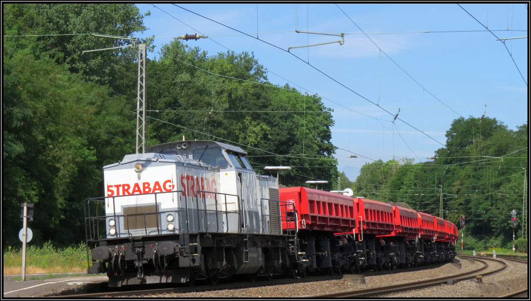 Die Strabag V100 (BR 203) wartet mit ihrer Altschotterladung auf die Weiterfahrt nach Stolberg,wo die Fuhre geleert wird. Der Zug wird bis dorthin geschoben.
Szenario von der Kbs 480,hier am Bhf von Eschweiler am 29.Juni 2015.