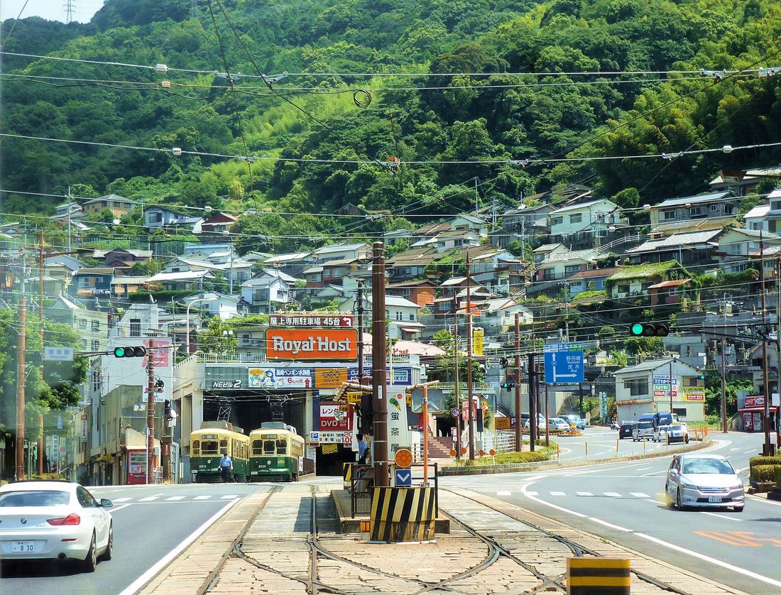 Die Strassenbahn von Nagasaki - Das Rollmaterial: Wagen 201-210. Im schwül-heissen Klima des sommerlichen Nagasaki mit seiner üppigen Vegetation und den steilen Hängen stehen vor der Einstellhalle Hotaru Jaya die beiden Wagen 363 und 203. 8.August 2013. 