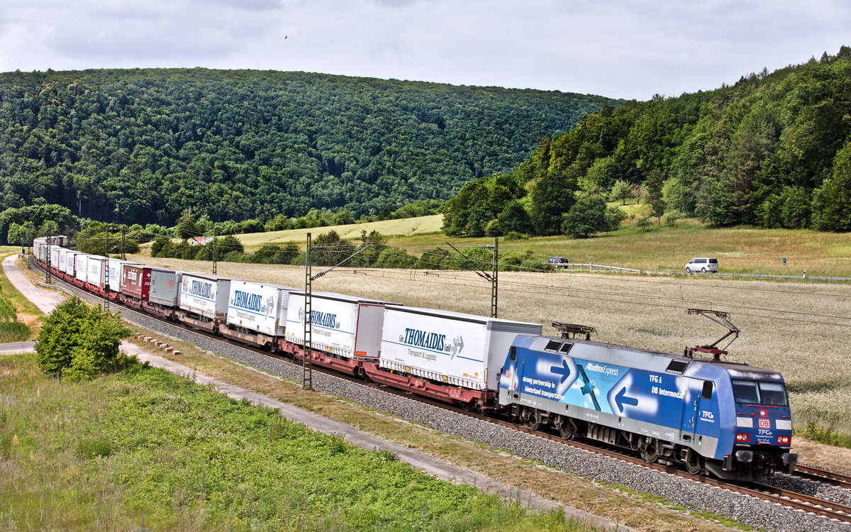 Die TFG 152 137-6 fährt mit einem Sattelaufliegerzug der Spedition Gebr.Thomaidis/Frankfurt in Gambach vorbei.Bild vom 16.6.2017