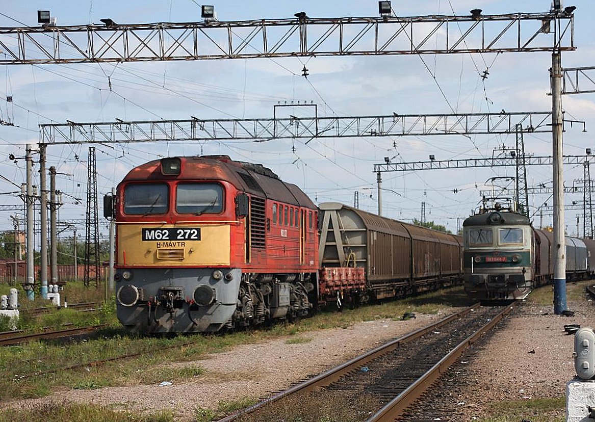 Die ungarische Taiga Trommel M 62272 und die slowakische Elektrolok 183044 warten vor Güterzügen auf Abfahrt aus dem ukrainischen Grenzbahnhof Tschop am 1.10.2009.