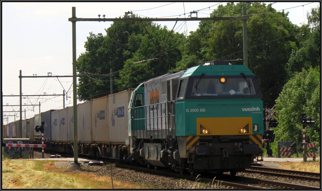 Die Vossloh G2000 BB von Locon zieht ihren Containerzug in Richtung Roermond.Hier zu sehen unweit der Gemeinde Echt-Susteren in Limburg,Niederlande im Juni 2015.