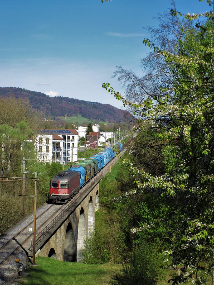 Dies ist mein 100. Bild! An einem wunderschönen Frühlingstag vom 13. April 2017, durchquert ein von der Ostschweiz herkommender Kies-Güterzug mit der SBB Re 6/6 Nr. 11683  Amsteg-Silenen  an der Front, die 93 Meter lange Wildbachbrücke bei Embrach, welche 1950 durch einen Neubau ersetzt wurde. 