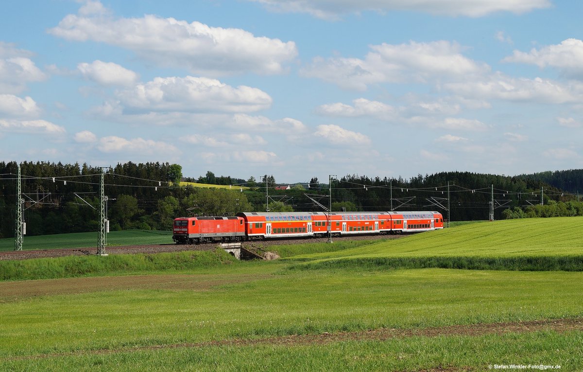 Dieser damalige Dosto RE 3 kommt uns mit einer 143 bei Feilitzsch entgegen. Er fährt am 26. Mai 2016 ins sonnige Frühjahr und wird in wenigen Km die bayrisch-sächsische Grenze erreichen.