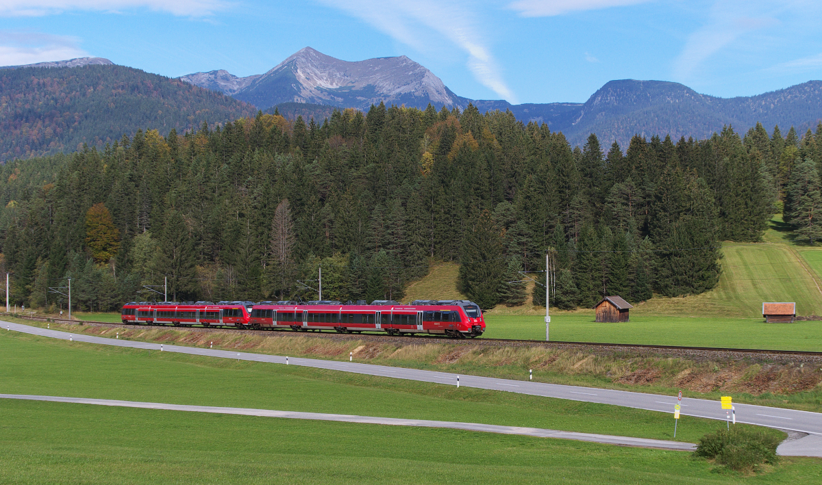 Doppelhamster - Da wir nur 100 Meter von der Mittenwaldbahn entfernt unsere Ferienwohnung hatten konnten wir auch mal spontan auf Pfiff an die Strecke.
Die RB München Hbf. - Seefeld in Tirol summt jetzt die Schmalenseehöhe hinauf und nach 960 Metern über NN geht es wieder bergab nach Mittenwald. Im Hintergrund das Estergebirge, das sich von Garmisch-Partenkirchen bis zum Walchensee hinzieht. 
Bahnstrecke 5504 München Hbf. Mittenwald Grenze am 07.10.2014