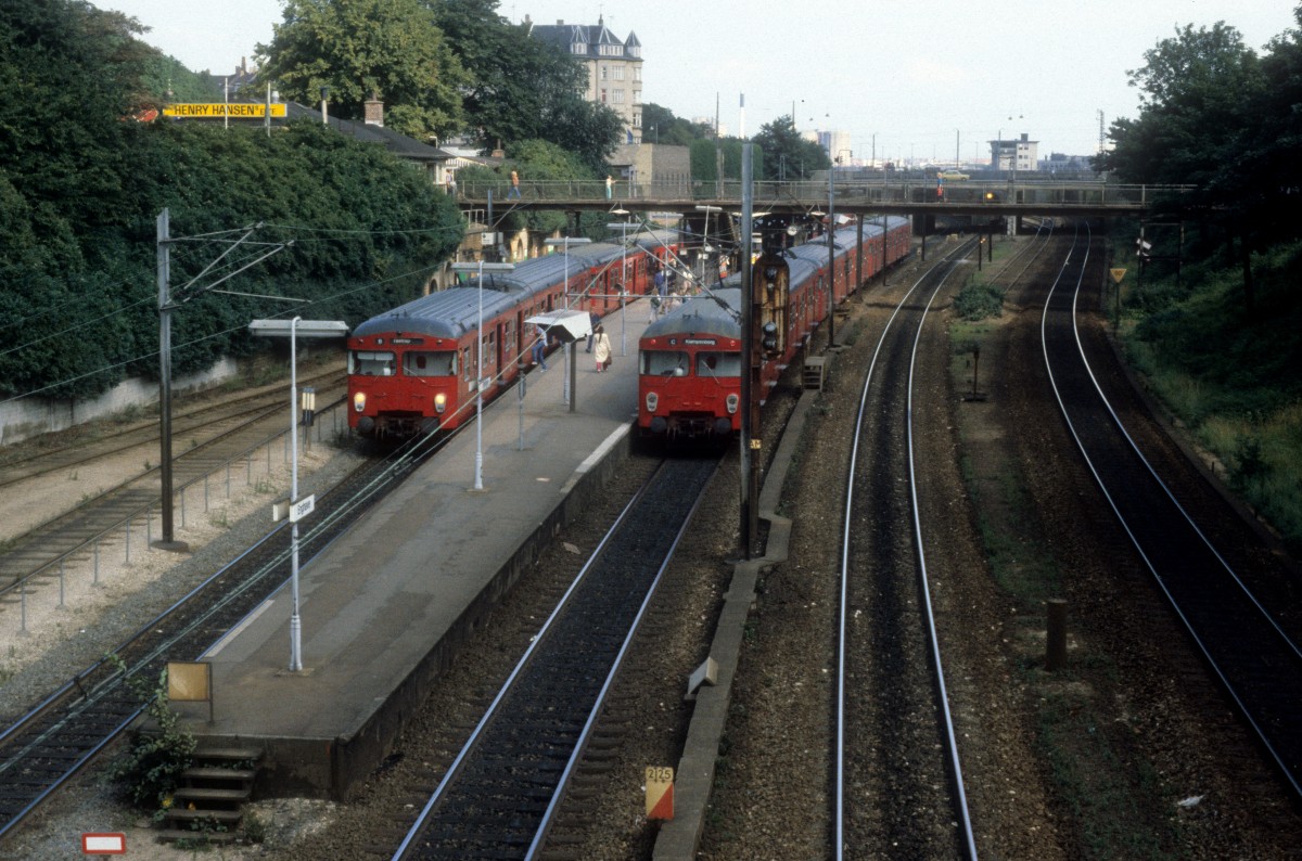 DSB S-Bahn Kopenhagen S-Bahnhof Enghave im August 1984: Zwei S-Bahnzüge (Linie B in Richtung Tåstrup / Linie C in Richtung Klampenborg) halten am Bahnsteig.