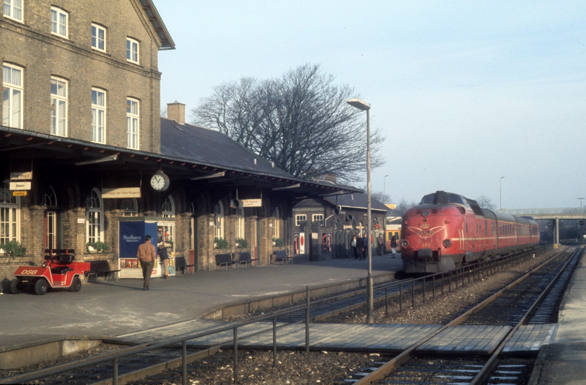 DSB Triebzug (MA 464; Lyntog, d.h. FD-Zug) Bahnhof Varde am 24. November 1975. - Der  Lyntog  (=  Blitzzug ) fuhr zu der Zeit von Kopenhagen nach Struer über Esbjerg, Varde und Holstebro. - Der Triebzug bestand aus einem Triebwagen, einem Mittelwagen AM (1. Kl.), einem Mittelwagen BM (2. Kl.) und einem Steuerwagen BS. Die Triebwagen und Steuerwagen wurden in den Jahren 1963 - 1966 von MAN gebaut. Die Triebzüge wurden 1990 ausgemustert. - Auf der Bahnstrecke zwischen Esbjerg und Holstebro fahren heute Arriva-Triebzüge des Typs LINT 41.