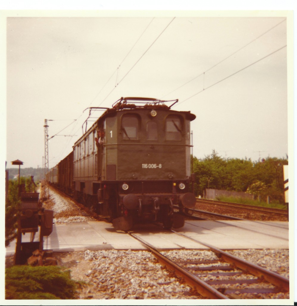 E 116 überquert mit ihrem Eilzug bei Rosenheim einen Bahnübergang. Das Foto stammt von meinem Vater Franz Bauch und entstand am 29.05.1974. 
