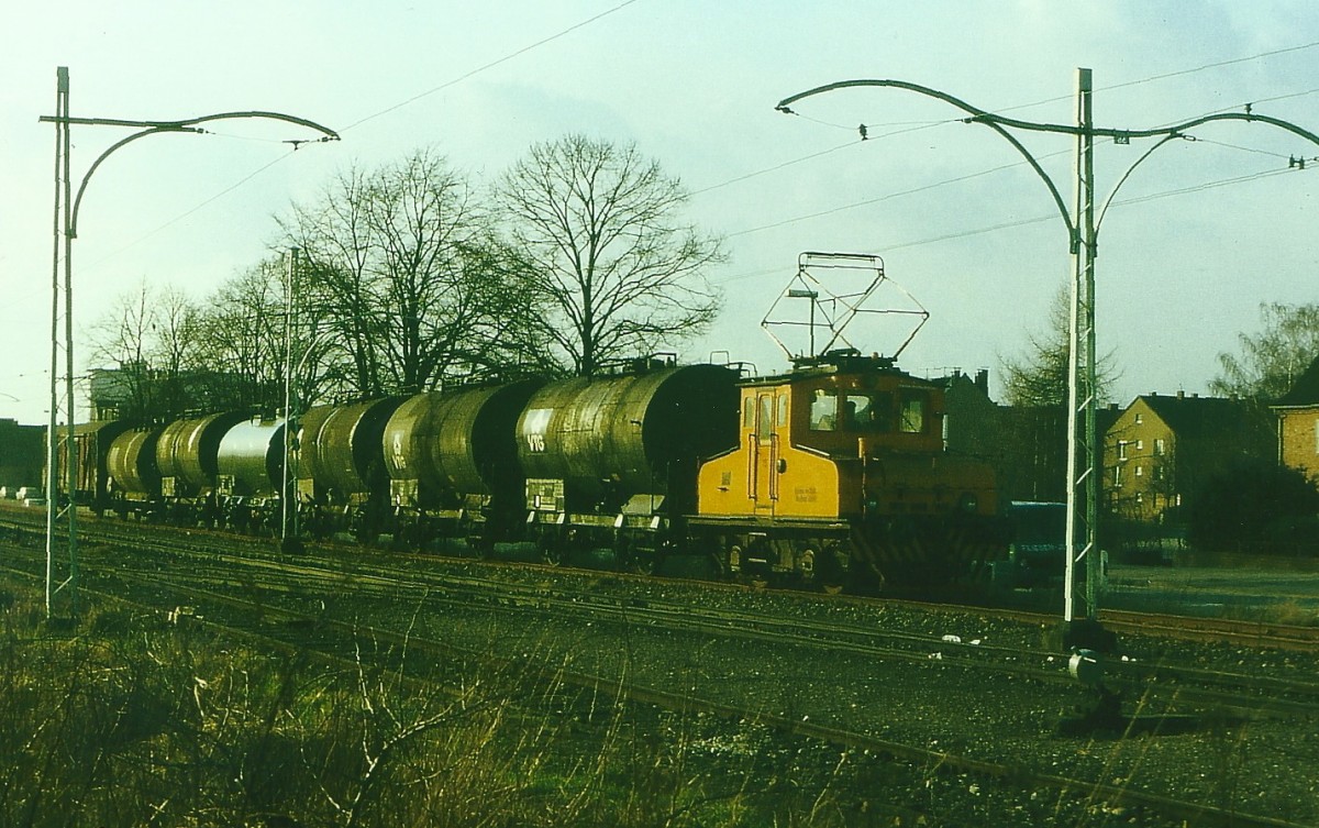 E 15 der BSM mit Kesselwagenzug vom Anschluss Shell auf der Strecke durch die Stadt, zwischen Monheim und Langenfeld, 18.1.78.