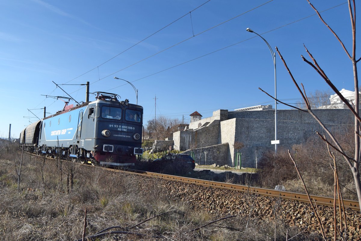 E-Lok 91-53-0-400308-9 der Constantin Grup mit kurzer Getreidewagengarnitur nach der Abfahrt aus Bahnhof Drobeta Turnu Severin. Im Hintergrund ist die alte Donaufestung Drobeta zu sehen. Foto vom 02.01.2017.