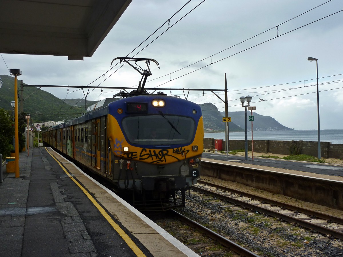 Ein 10M3 fährt am 26.07.2014 in den Bahnhof Simonstown ein. Da der Bahnhof direkt am Strand liegt sind einige der Gleise recht versandet.