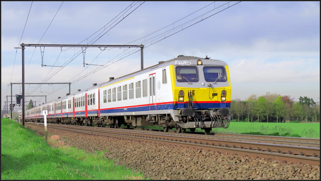 Ein belgischer Regionalzug mit Steuerwagen voraus kommt mir hier unweit von Tongeren vor die Linse. Szenario bildlich festgehalten am 21.April 2016.