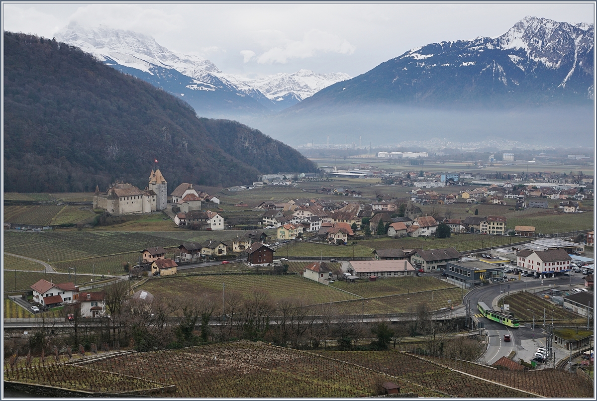 Ein Blick auf Aigle: Rechts unten verlässt der A-L BDeh 4/4 313 mit seinem Bt 363 auf der Fahrt von Leysin nach Aigle nach der Spitzkehre Aigle Dépôt A-L, rechts im Bild ist das Schloss von Aigle zu sehen und in der Bildmitte, von Wolken verhüllt die Dents de Midi.
7. Jan. 2018