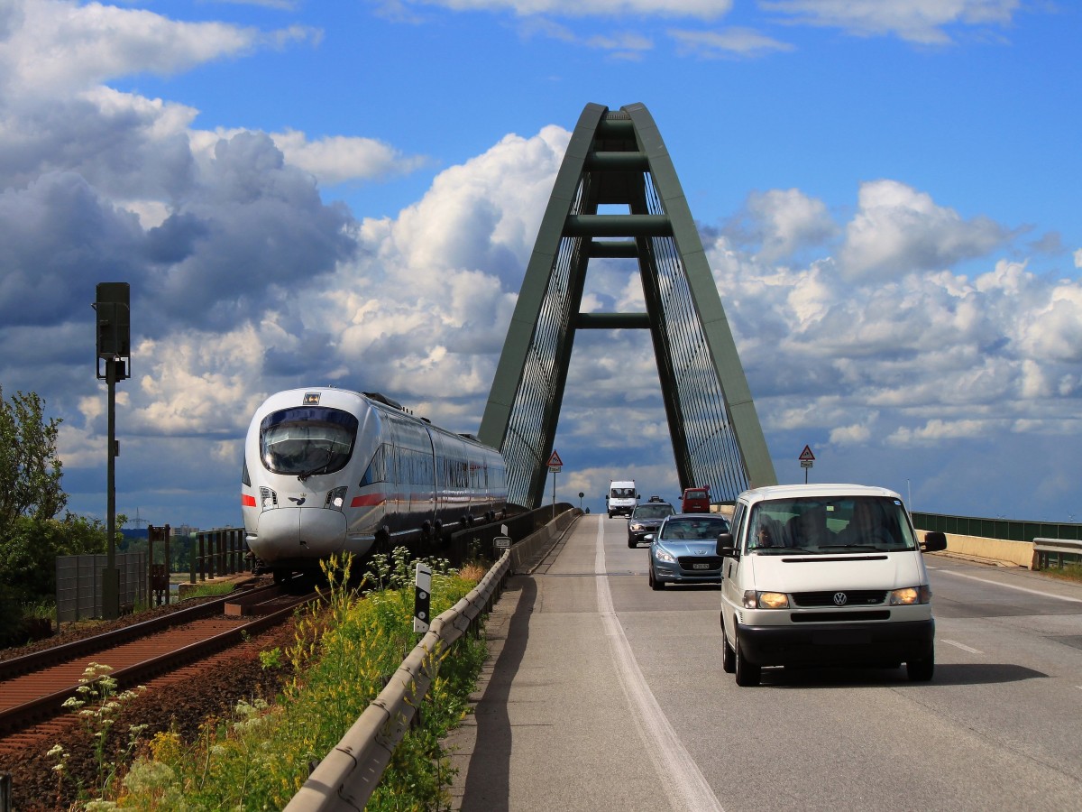 Ein Diesel-ICE der Baureihe 605 von Berlin nach Kopenhagen jagt am 13.06.2014 über die Fehmarnsundbrücke nach Puttgarden um das Fährschiff pünktlich zu ereichen das ihn über den 19km breiten Fehmarnbelt nach Rødby auf Lolland (Dänemark) bringt. Da wird mancher Autofahrer dumm aus der Wäsche geschaut haben als der ICE mit hohen Tempo rechts überholte, weil wegen des starken Windes die Geschwindigkeit auf der Strasse auf 60 km/h beschränkt war.