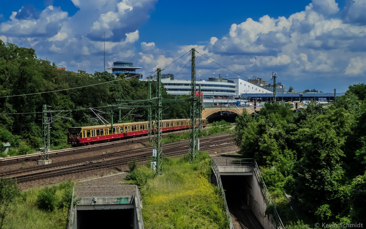 Ein Dreiviertelzug der BR 480 verlässt auf der Berliner Ringbahnlinie S42 den Bahnhof Gesundbrunnen in Richtung Wedding. Im Hintergrund erkennt man das Gesundbrunnen Center sowie das im Bau befindliche künftige Empfangsgebäude des Bahnhofs Berlin Gesundbrunnen. (11.07.2014)