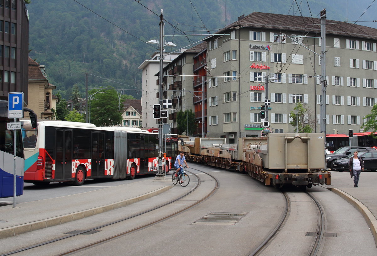 Ein Güterzug, der mitten durch die belebte Stadt auf  Straßenbahngleisen  fährt, das ist Chur. 
Den Regios Chur - Arosa werden ab und zu Güterwagen mitgegeben.

Chur, 14. Juni 2017