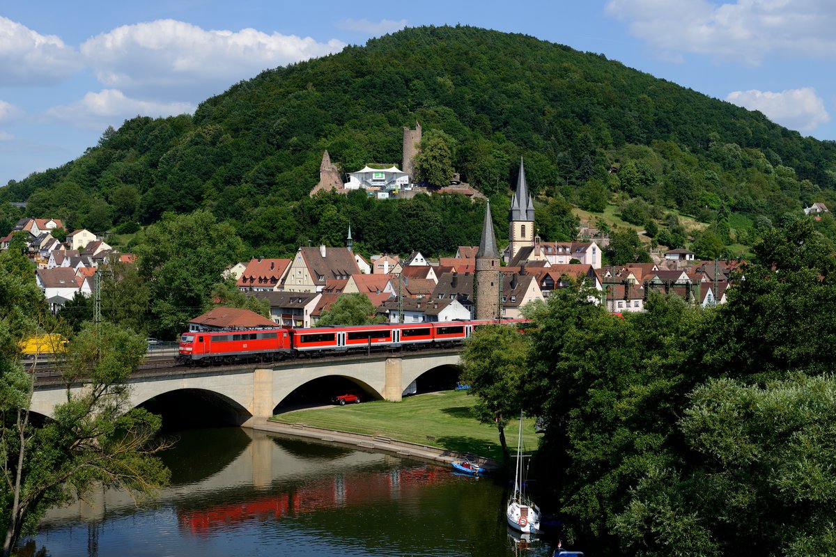 Ein Klassiker, schon oft gesehen, aber immer wieder schön: Der Blick auf Gemünden mit Saalebrücke und Burg im Hintergrund. Am 19. Juli 2013 schiebt 111 183 die RB 58381 nach Gemünden.