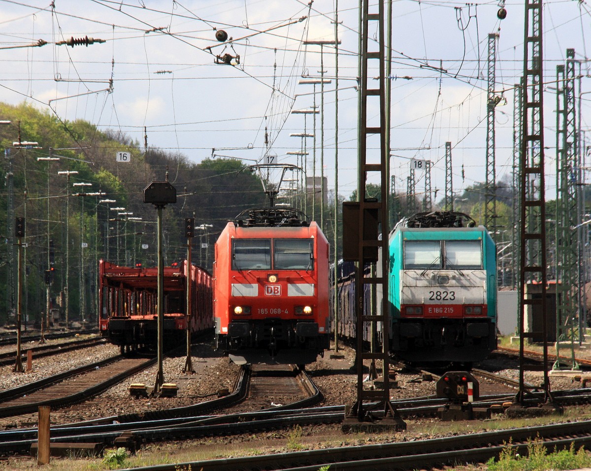 Ein Nachschuss von der 185 068-4 DB rangiert in Aachen-West und auf dem Nachbargleis steht eine Cobra 2823 mit einem langen Citroen-Auto-Zug und wartet auf die Abfahrt nach Zeebrugge-Pelikaan(B) Bei Sonne und Wolken am Nachmittag vom 18.4.2014.