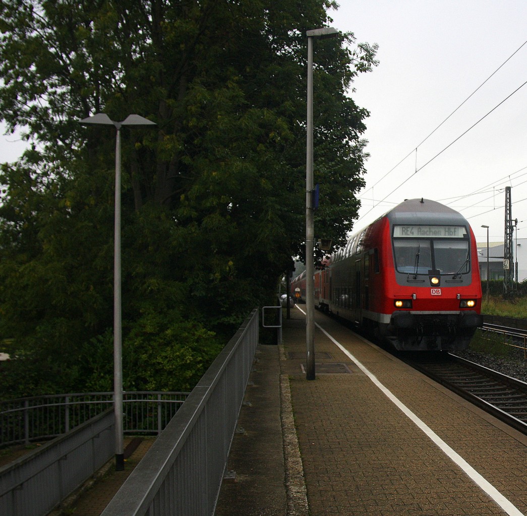 Ein RE4 von Dortmund-Hbf nach Aachen-Hbf und am Zugende ist die 111 118-6 DB 
kommt die Kohlscheider-Rampe hoch und fährt durch Kohlscheid in Richtung Richterich,Laurensberg,Aachen-West.
Bei Regenwetter am Morgen vom 7.9.2015.