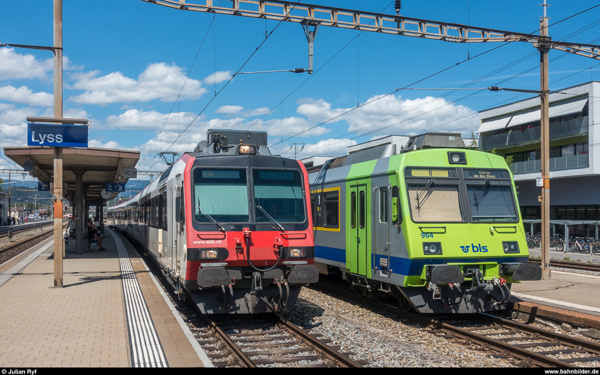 Ein SBB Domino als Ersatzzug für den RE nach Bern und ein BLS RBDe-Pendel als Regio Lyss - Büren an der Aare treffen sich am 11. August 2018 im Bahnhof Lyss.