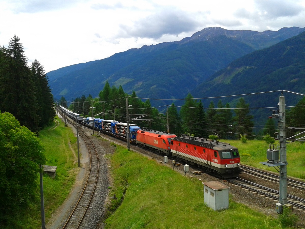 Eine 1144 und eine 1116 mit einem Güterzug am 21.6.2015 bei der Durchfahrt in Penk.