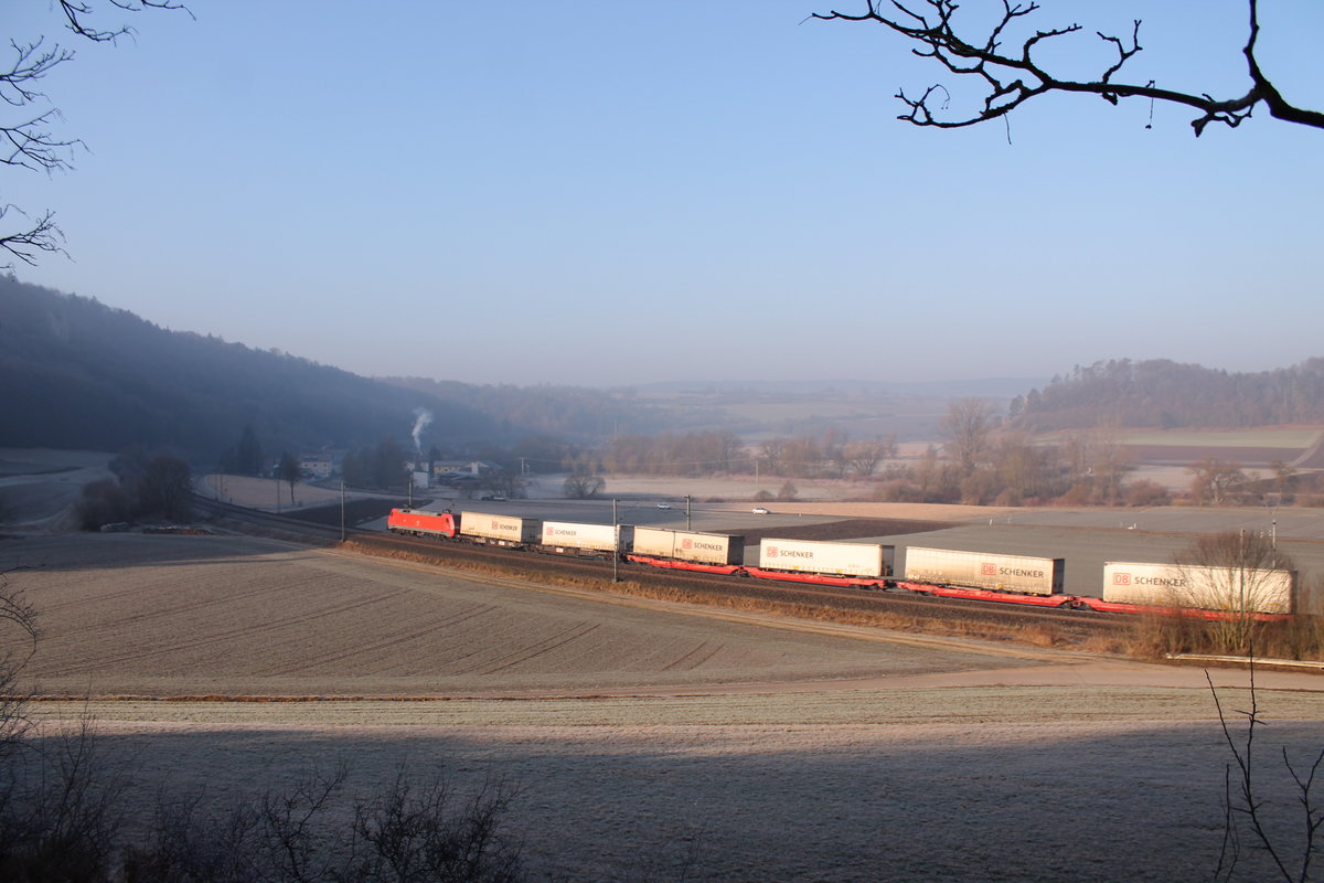 Eine 152 mit ihrem DB Schenker Zug bei Breitenfurt auf dem Weg in Richtung Treuchtlingen. Die Sonne ist noch schwach an diesem 16.02.2017, trotzdem leuchtet sie alles im zarten Licht von der Seite aus.