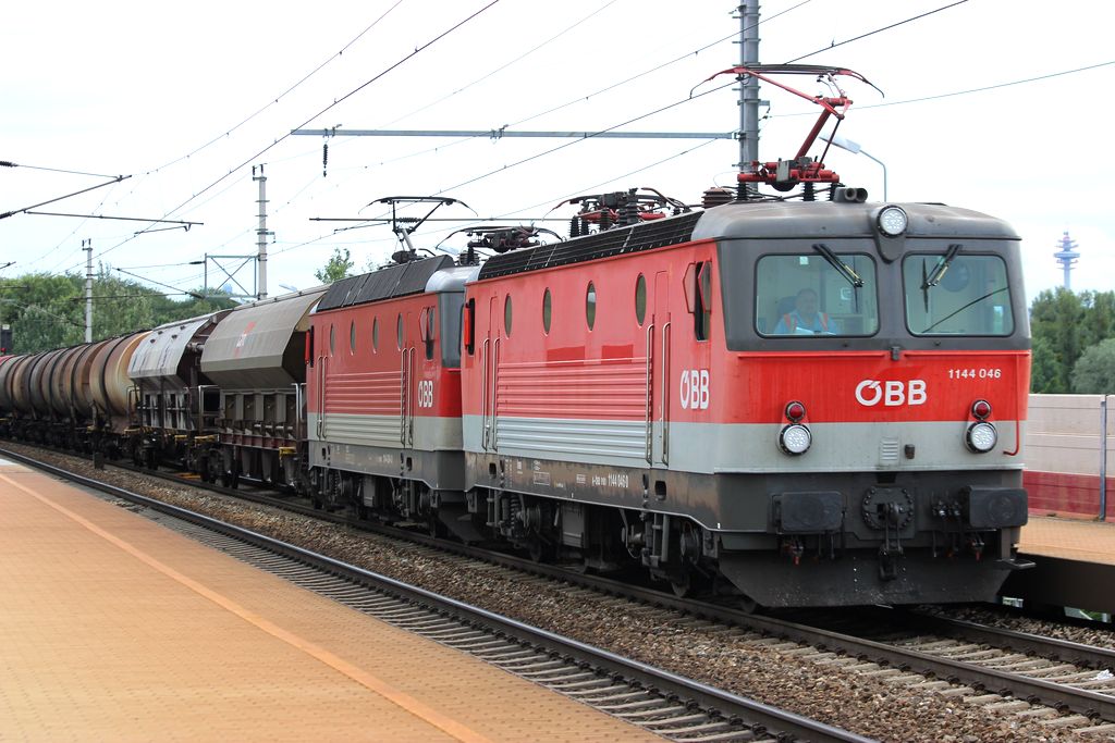 Eine Doppeltraktion von 1144ern (046+094) zieht einen Güterzug durch die Haltestelle Wien-Praterkai. 10.7.2014