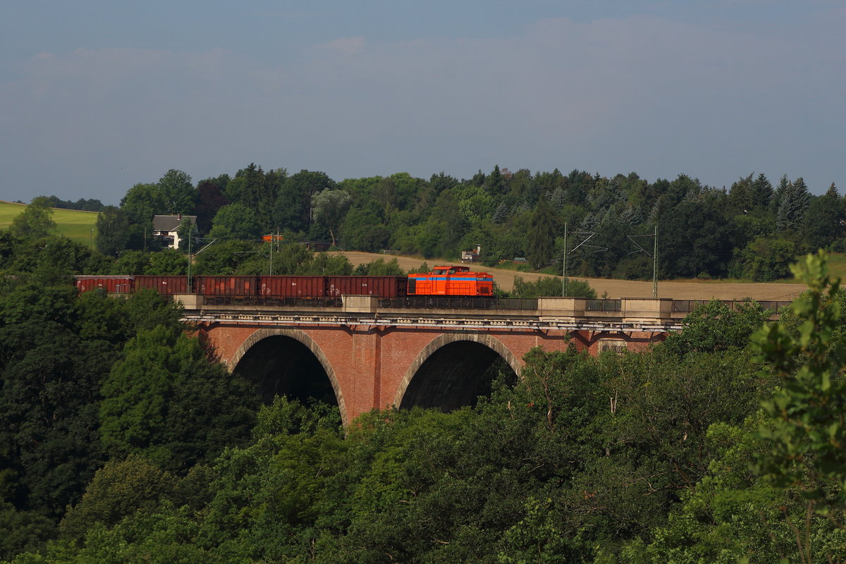 Eine SWT V100 in orange mit Schrottzug auf der ELstertalbrücke bei Jocketa. Aufgenommen am 01.08.2017