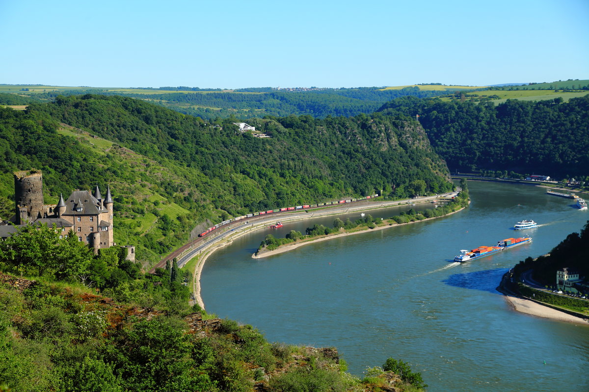 Einen schönen Blick auf den Loreleyfelsen und den Rhein ergibt sich bei Sankt Goarshausen-Patersberg. Am 27.05.2017 war eine unbekannte 185 mit einem nordwärts fahrenden Containerzug unterwegs.