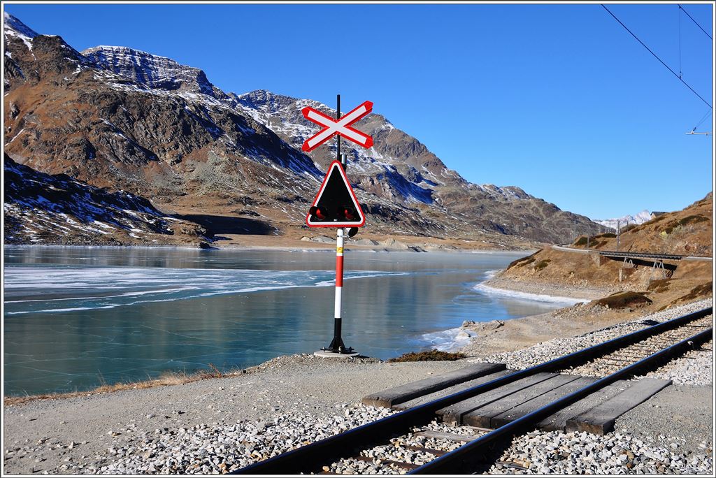Es könnte auch ein Sommerbild sein, wenn nur das Eis nicht wär. Bahnübergang bei Ospizio Bernina. (10.12.2015)