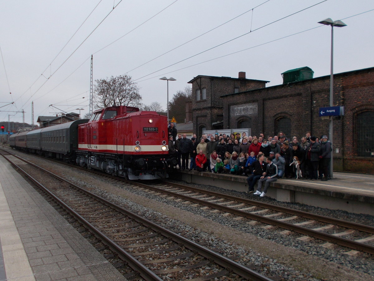 Für ein Gruppenfoto postierten sich die Teilnehmer einer Sonderfahrt nach Putbus,am 26.November 2016,vor der Zuglok 112 565 in Bergen/Rügen.