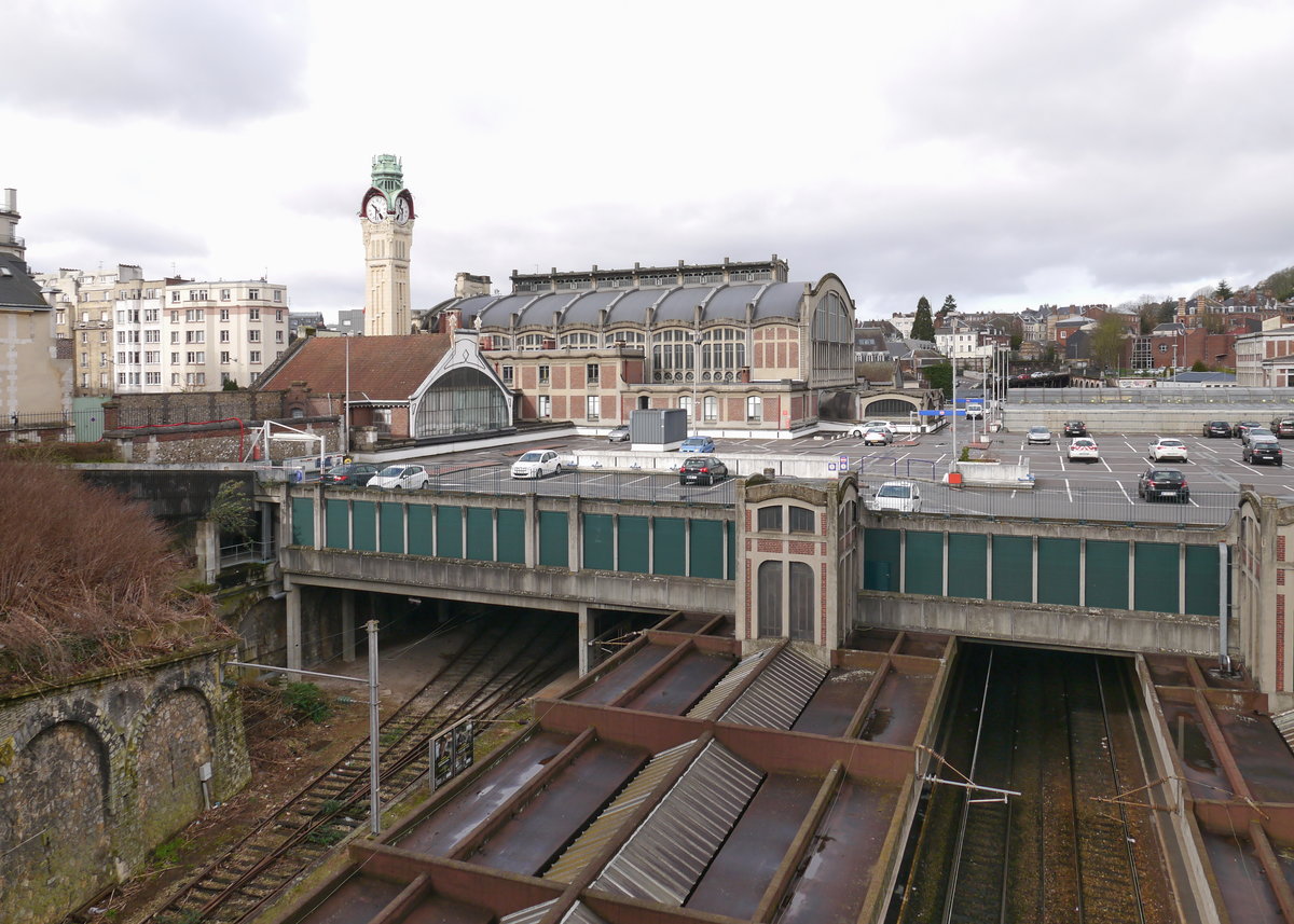 Gare de Rouen-Rive-Droite.
Der heutige Bahnhof auf dem rechten Seineufer wurde 1928 eröffnet. Hier zu sehen die beengt im Einschnitt liegenden Bahnsteige, die mit einer Parkpalette überbaut wurden und die Bahnhofshalle.Durch die sehr beengte Lage zwischen zwei Tunnels und in einem Einschnitt sind die Bahnsteig- und Gleislängen äußerst begrenzt und nicht erweiterbar. Es wird diskutiert stattdessen einen neuen Bahnhof am linken Seineufer zu bauen. Da dazu aber auch eine Seinebrücke und lange Zufahrtstunnel nötig sind, wird dies immense Kosten verursachen und die Umsetzung ist noch lange nicht sicher.

28.03.2016 Rouen-Rive-Droite