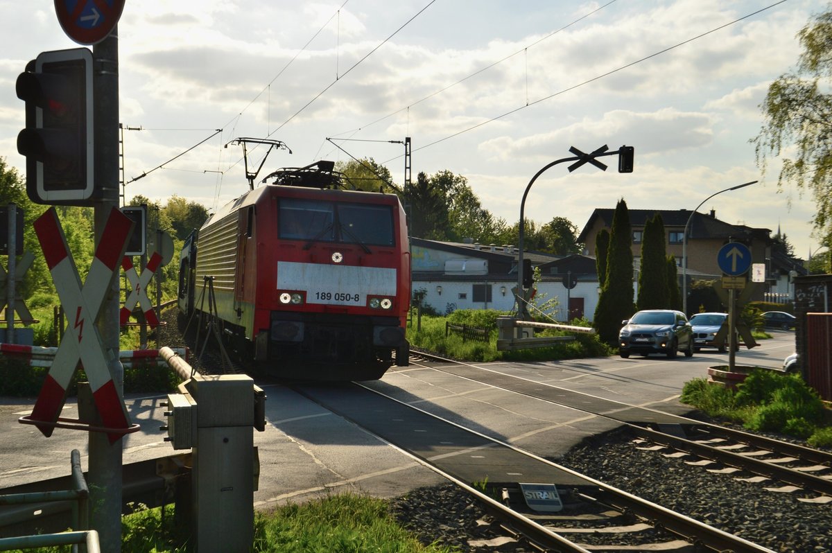 Gegenlichtaufnahme von der 189 050-8 mit einem leeren Autotransportwagenzug am Bahnübergang Kölner Straße in Jüchen. 9.5.2017