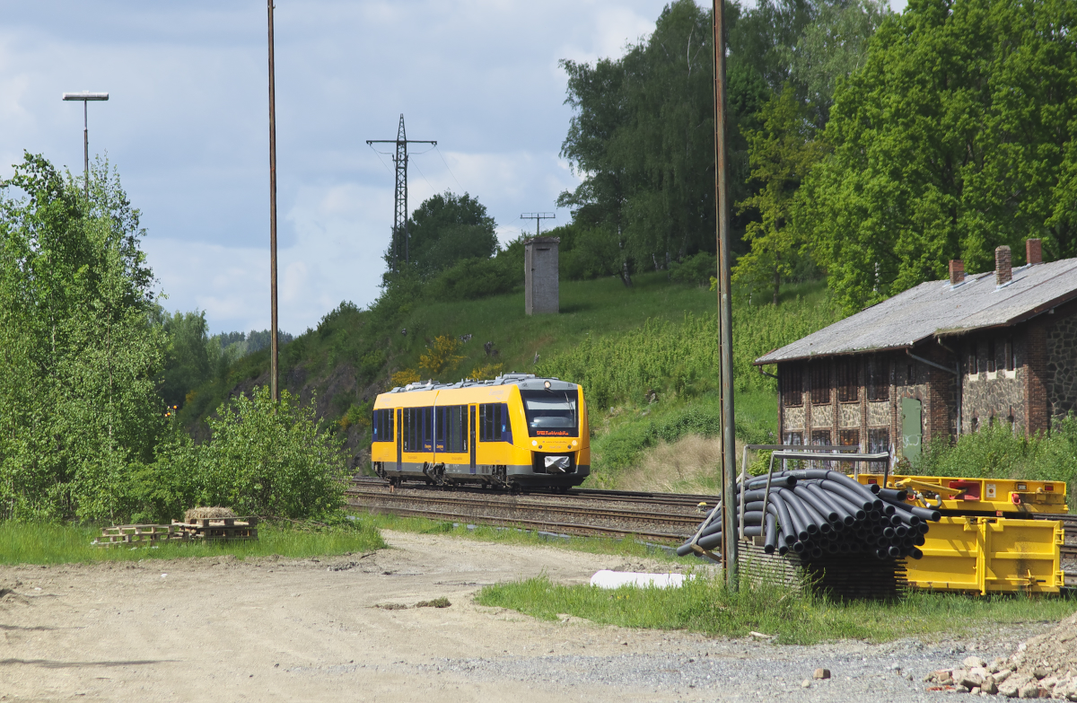 Genau zwischen die Lampenmasten passt 1648 206 der Oberpfalzbahn. Die Masten erheben nicht den Anspruch gerade zu stehen. Das Gelände am ehemaligen Rbf. Oberkotzau wurde als Lager benutzt, denn die Bahnsteige in Oberkotzau wurden erneuert. Der LINT der Oberpfalzbahn ist auf dem Weg nach Marktredwitz aber nicht auf direktem Weg sondern über Selb-Plößberg, As und Cheb. Daher wird der Triebwagen in Oberkotzau von der Hauptstrecke abzweigen und weiter die Bahnstrecke 5027 durch das bayerische und böhmische Vogtland befahren. Oberkotzau 25.05.2017