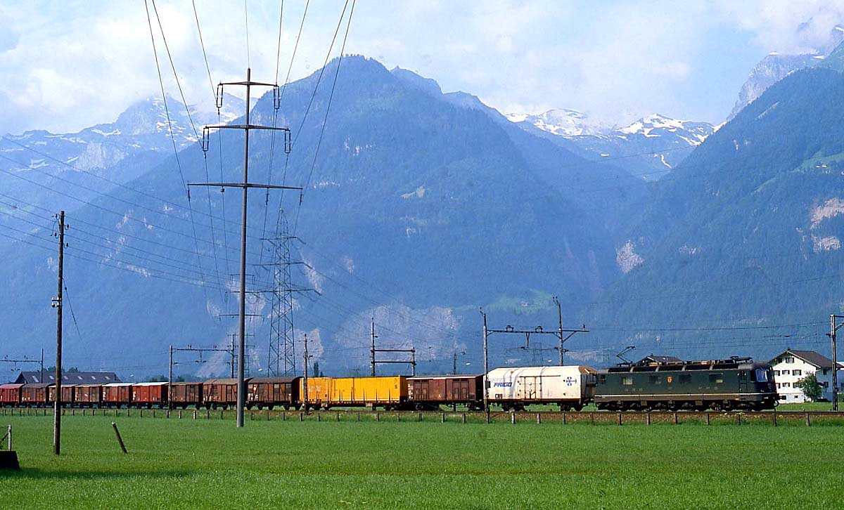 Gotthardbahn 1983: Im Juli 1983 ist eine Re 6/6 mit einem für die damalige Zeit typischen Güterzug zwischen Erstfeld und Altdorf unterwegs. Schon erstaunlich, welchen Wandel die Güterbeförderung seitdem erfahren hat...