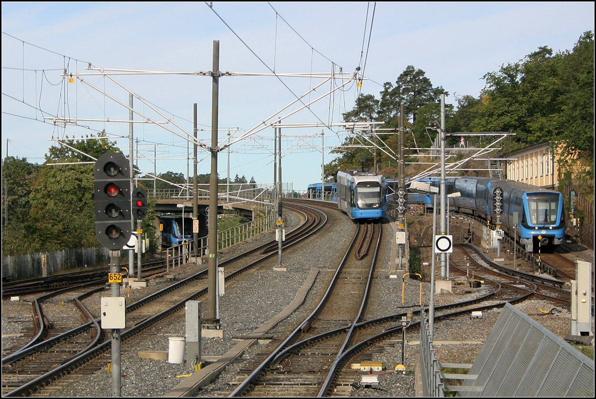 Grüne Linie und Nockebybahn beieinander - 

Blick vom Bahnhof Alvik nach Westen. Aus befinden sich die Tunnelbana-Streckengleise aus und in Richtung Hässelby strand. Die beiden mittleren Gleise werden von der Nockebybahn befahren. Die dazwischen liegenden Gleise werden von der U-Bahn und der Stadtbahn gemeinsam benutzt, sie haben deshalb sowohl Stromschienen als auch Oberleitungen. Über diese Gleise wenden die U-Bahnen, die in Alvik enden und für die Nockebybanan stellen sie die Verbindung zu ihrem dortigen Depot her. 

Stockholm, 29.08.2007 (M)