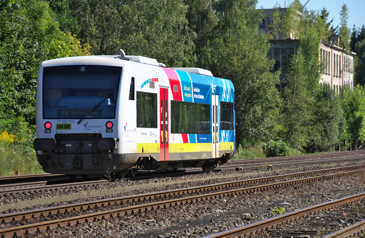 Gute Nachbarn mit neuen Verbindungen, so wirbt VT 650.703 in deutscher und tschechischer Sprache, das Bahnland Bayern verknüpft mit der Region Karlovarsky Kraj (Region Karlsbad). Die neue Verbindung Hof - Selb Plößberg - As (Asch) - Cheb (Eger) - Marktredwitz wurde im Dezember 2015 wiedereröffnet und ein Teilstück der Strecke reaktiviert. Die Oberpfalzbahn fährt im Zweistundentakt. 31.08.2016 - VT 650.703 in Oberkotzau, im Hintergrund die ehemalige Hefe- und Spiritusfabrik Oberkotzau.