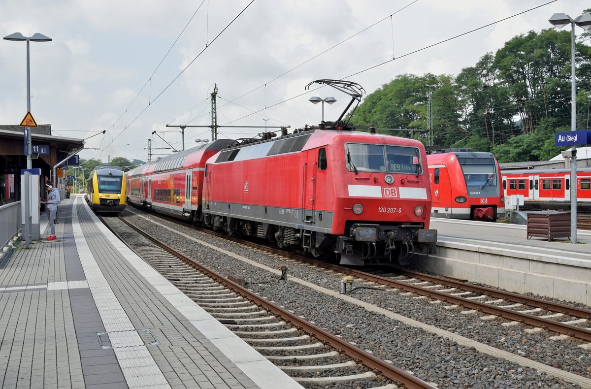  Hochbetrieb  am 13.08.17 im Bahnhof Au (Sieg): Während HLB VT 261 (648 161-661) als RB 90 (61718) Westerburg - Siegen Hbf den Bahnhof verlässt, setzt DB Regio 120 207 (schiebend) mit RE 9 (10916)  Rhein-Sieg-Express , von Siegen kommend, die Fahrt nach Aachen Hbf fort. Rechts daneben ist ein Teil von DB 423 038/538 als Teil einer 423er Doppelgarnitur zu sehen, die vor wenigen Minuten als S 12 (S-Bahn Köln) von Köln-Ehrenfeld kommend das Ziel erreicht hat. Ganz rechts steht auf einem Abstellgleis DB 420 457/957 als S-Bahn Köln. 