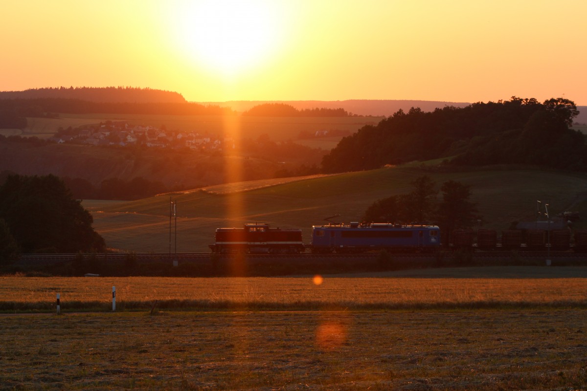 Holzvollzug mit ziehender 112 565 und 155 045 der Press bei Sonnenuntergang schlängeln sich durch das Vogtland nach Plauen. Gesehen am 30.6.2015