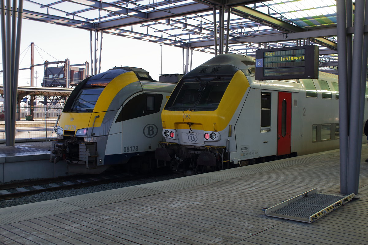 IC mit dem Steuerwagen (M6) welcher nach Eupen ging rechts. Am anderen Bahnsteig ein Triebwagen der Baureihe AM 08 für die Fahrt nach Antwerpen. Aufgenommen am 20.01.2017 in Oostende.