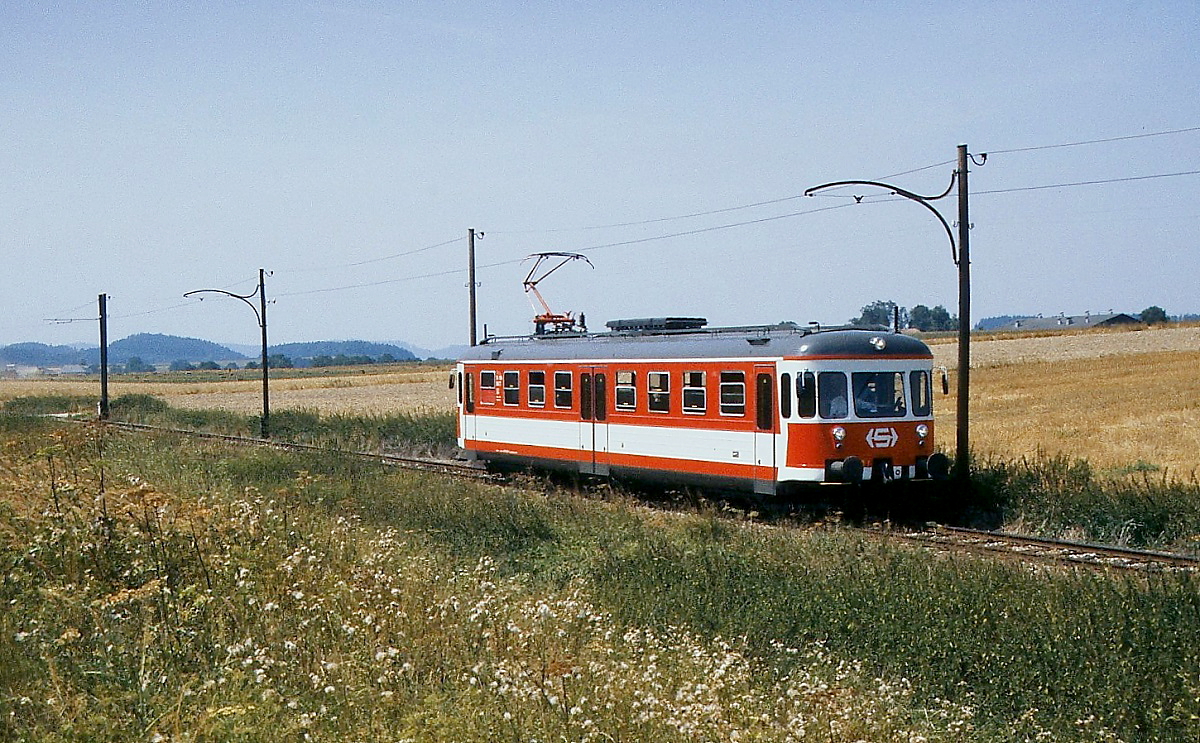 Idyllisch führte die Lokalbahn Lambach - Haag durch den Hausruck. ET 24.104 ist im Juli 1992 in Richtung Lambach unterwegs. Dieser Triebwagen stammte von der Bad Eilsener Kleinbahn (dort ET 204), die ihn nach der Einstellung 1967 an die Montafonerbahn verkaufte, dort wurde er als ET 10.101 eingesetzt. Außerdem erhielt das Gleichstromfahrzeug bei der Montafonerbahn ein Hilfsaggregat, damit er in den mit ÖBB-Wechselstrom elektrifizierten Bahnhof Bludenz einfahren konnte. Mit diesem Aggregat konnte er auch bei der Lokalbahn Lambach - Haag auf dem gemeinsamen Teilstück mit der ÖBB fahrdrahtunabhängig verkehren. Stern und Hafferl erwarb ihn daher 1991 als Ersatz für die alten Fahrzeuge.
