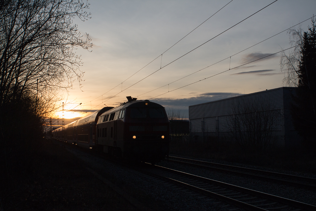 In der angehenden Abenddämmerung des 22.02.17 konnte ein 218-Doppelstock-Sandwich-Zug von München nach Mühldorf in Poing im Bilde festgehalten werden.