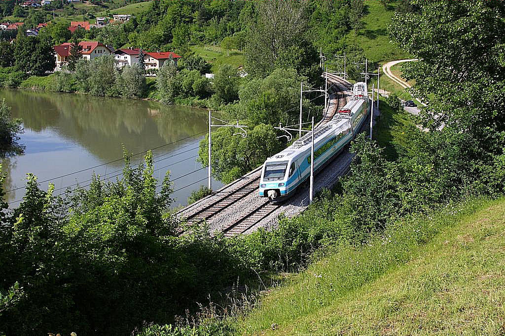 In weitem Bogen führt die Bahnstrecke unterhalb der Bergkirche Maria Gradec um
die Savinja herum. Unterhalb der Kirche ist am 29.5.2011 ein Pendolino der SZ nach Lubljana unterwegs.