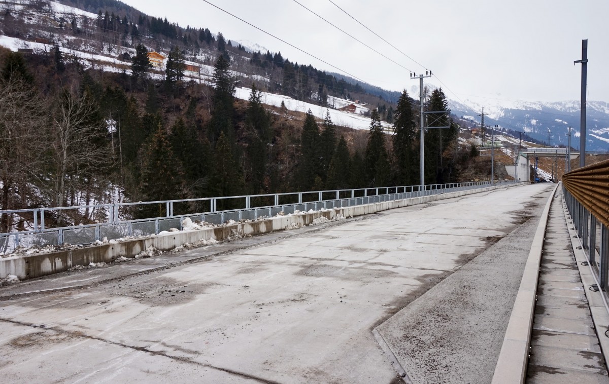 Inzwischen wurden die Arbeiten an der neuen Angerschluchtbrücke wieder aufgenommen. Die Oberleitungsmasten auf der Brücke, sind, wie zu sehen ist, aufgestellt und teilweise wurden auch schon Leitungen montiert. Die Betonschicht, dieser der Frost in den Jahren schon zugesetzt hat, wurde auch schon abgeschremmt.
Aufgenommen am 13.3.2016
