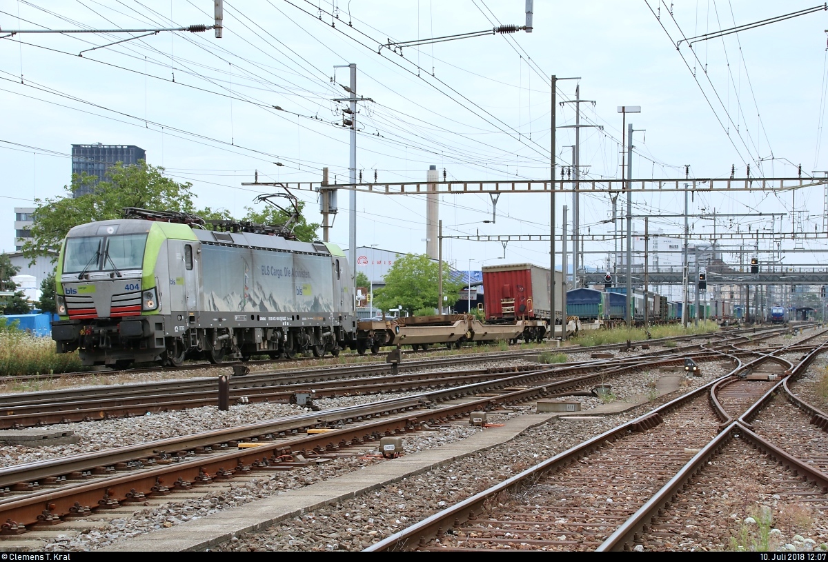 KLV-Zug mit Re 475 404-0 (Siemens Vectron) der BLS Cargo AG durchfährt den Bahnhof Pratteln (CH) in westlicher Richtung.
Aufgenommen von der Güterstrasse.
[10.7.2018 | 12:07 Uhr]
